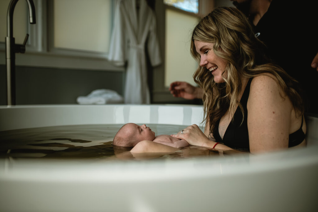 First hour after birth photography in DFW, documenting skin-to-skin bonding between mother and newborn in a quiet, emotional moment.