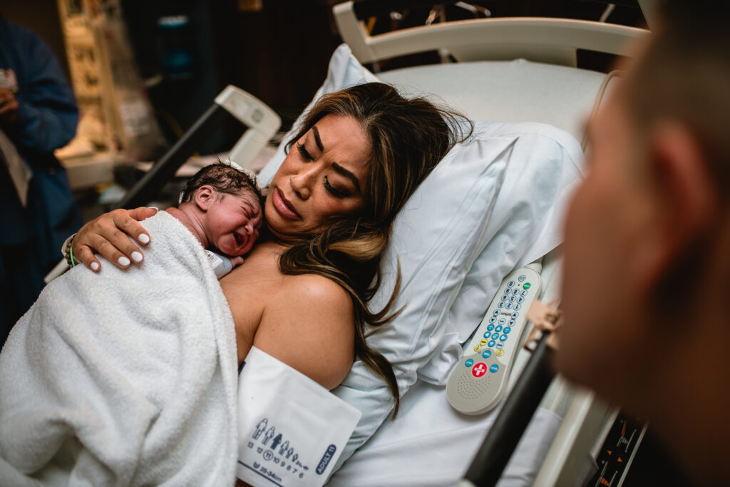 Unposed and intimate moment after birth in DFW, with parents holding their newborn in a quiet and emotional scene.
