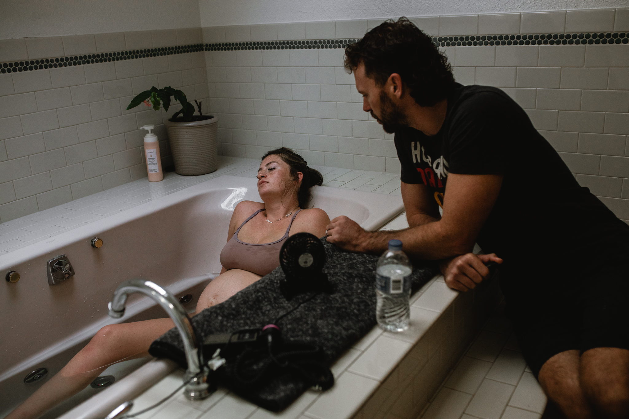 Partner supporting mother during labor in Fort Worth, an emotional and tender moment documented by a DFW birth photographer.