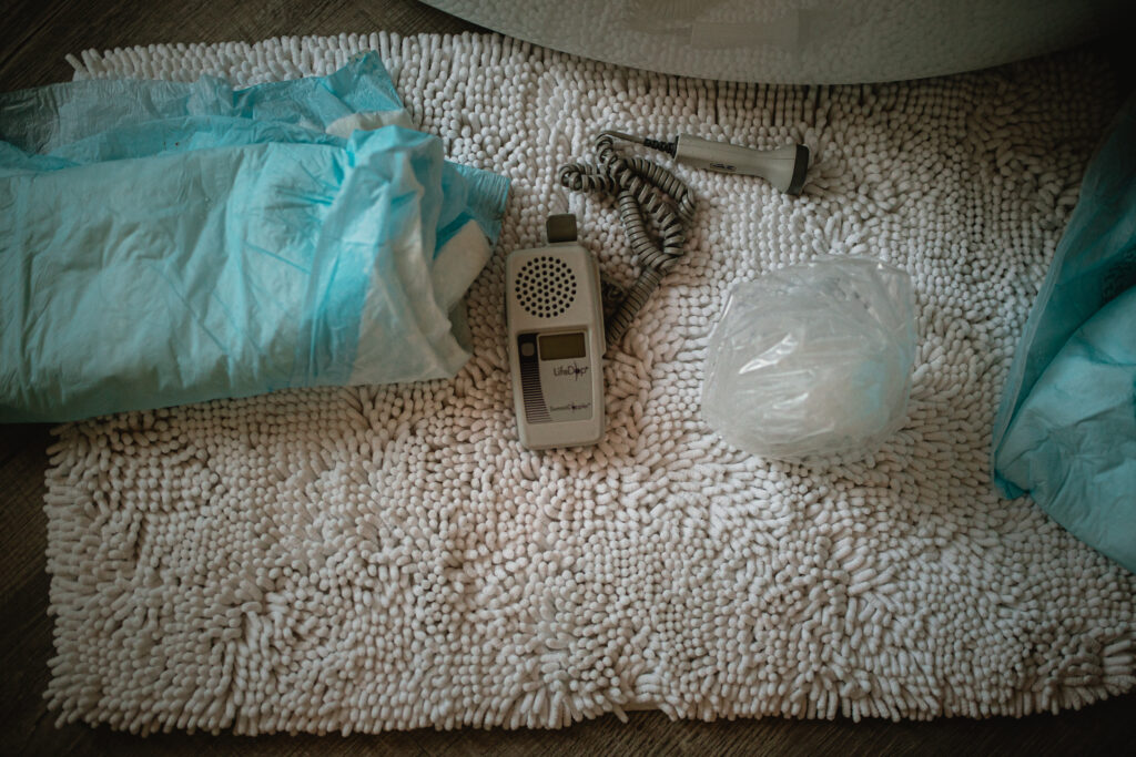 Birth center supplies laid out on a blanket — gloves, birth kit, monitor and sterile instruments