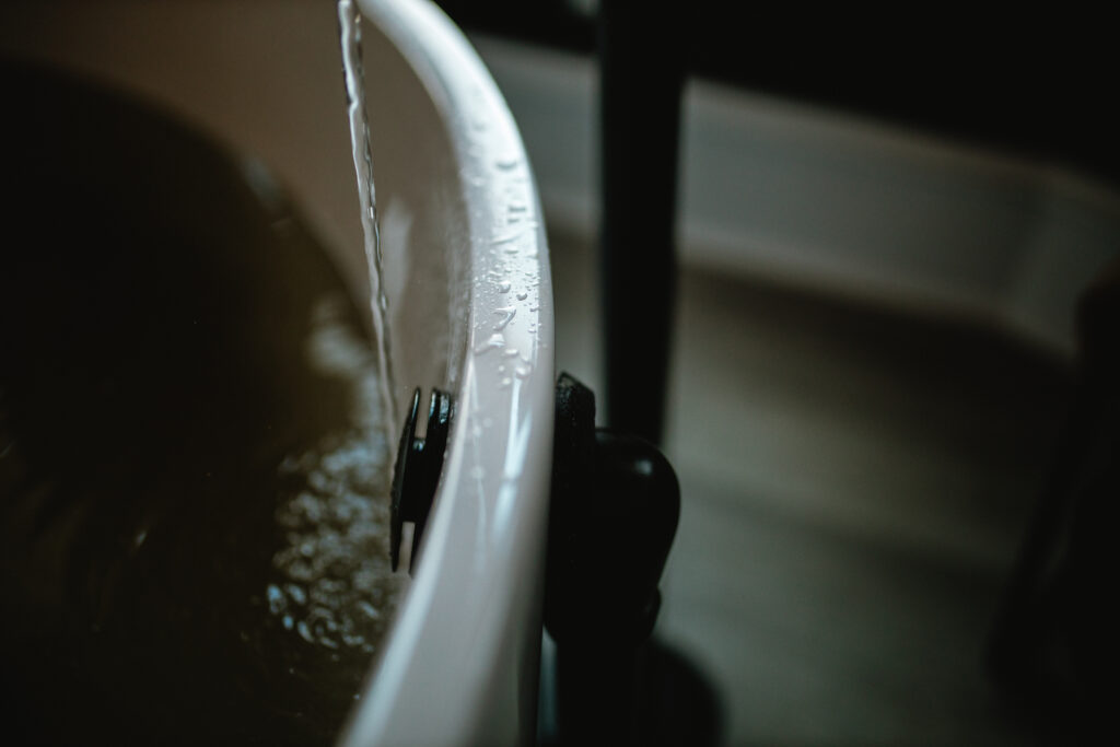 Close-up of water spilling gently over the rim of the birth tub during labor