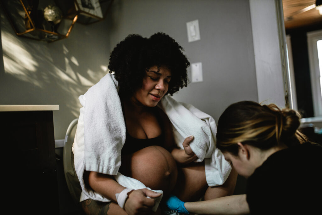 Mother leaning forward and smiling through a brief moment of relief between contractions