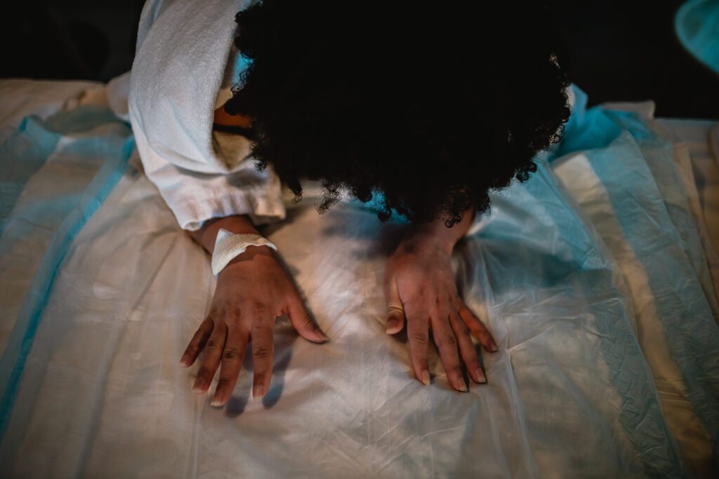 Birth partner preparing the bed with fresh linens and birth pads as they transition from the tub