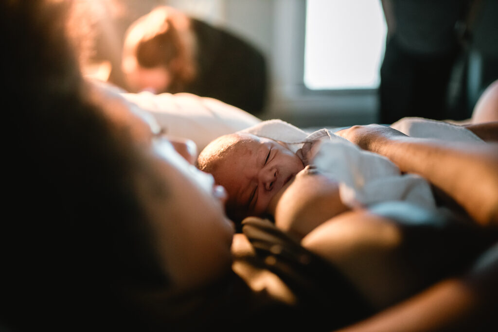 Close-up of newborn resting on mother’s chest during the first quiet minutes after birth