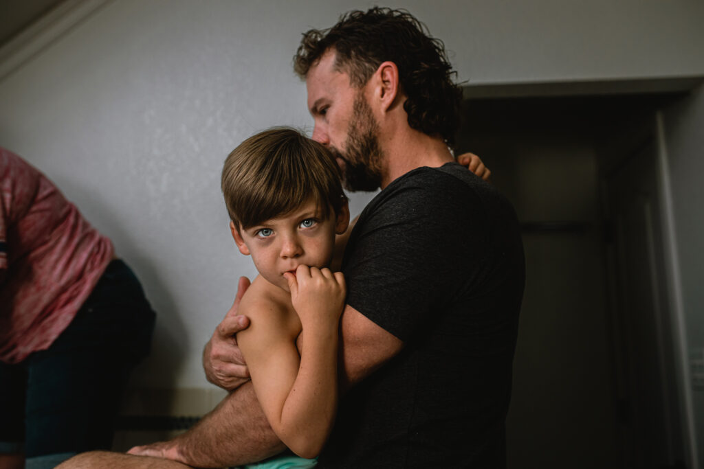 Big brother helping during home birth — sibling comforted while mother labors