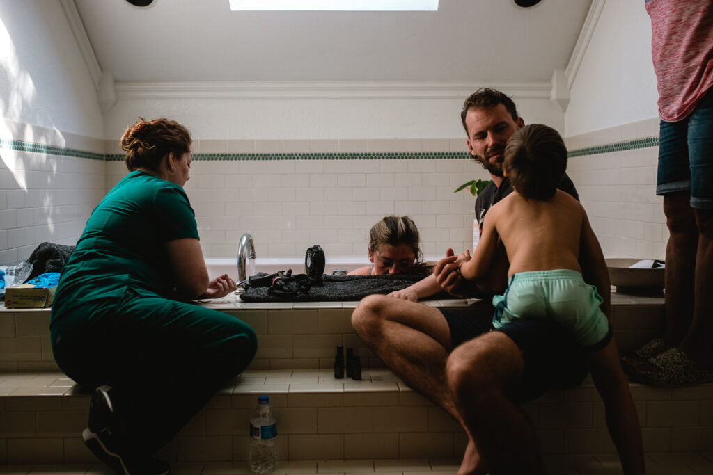 Home birth story — family gathered around as mother labors in bathtub
