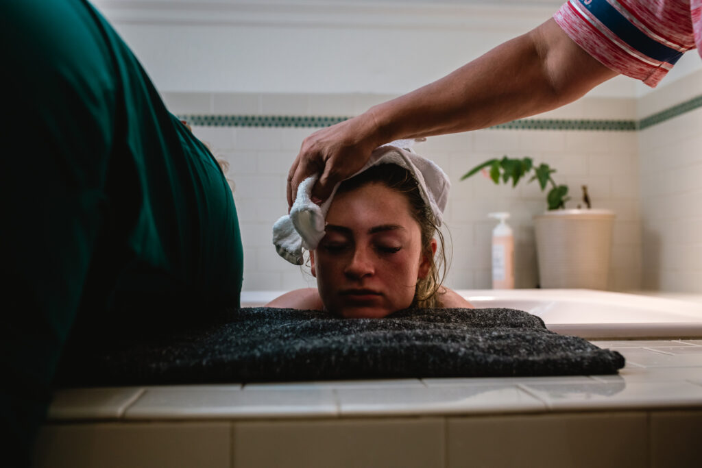 Birth team offering comfort with cold cloth during active labor