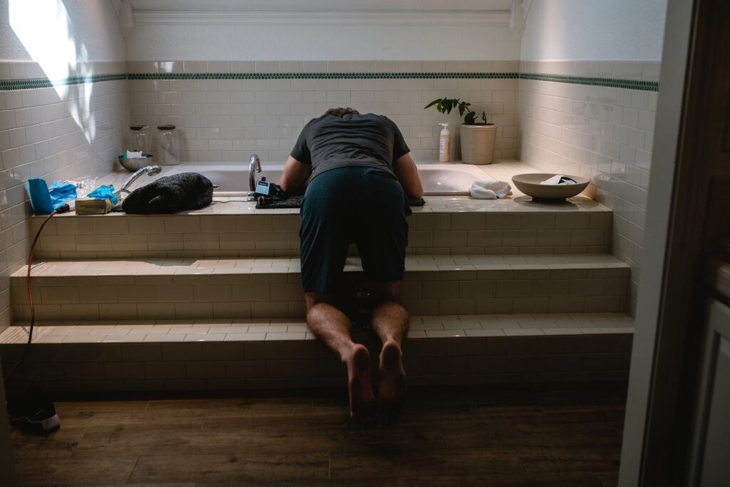 Wide documentary view of home birth bathroom during active labor