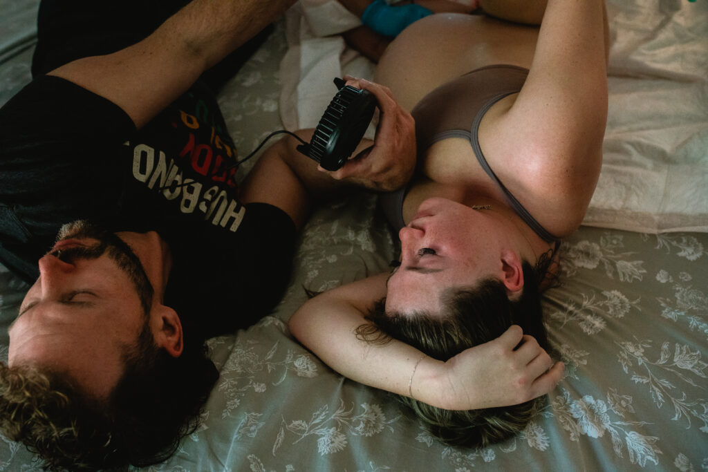 Parents resting together after birth — emotional first moments after home birth