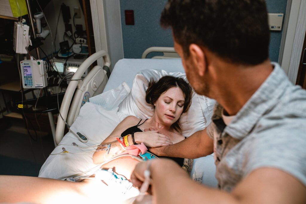 Mother focusing on her breathing while laboring in a hospital bed during early pushing phase