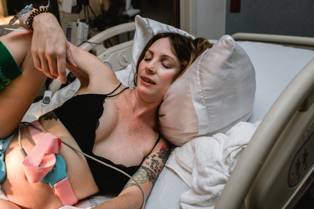 Laboring mother closing her eyes and breathing deeply through a contraction while supported by her care team