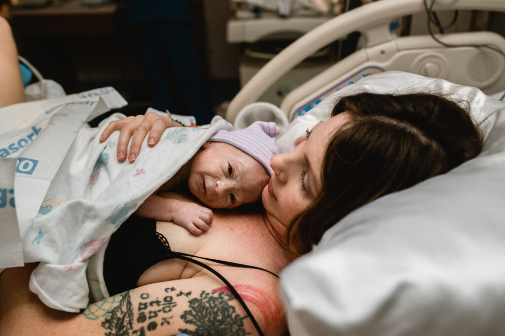 Father assisting during delivery as mother pushes using tug-of-war technique supported by OB team