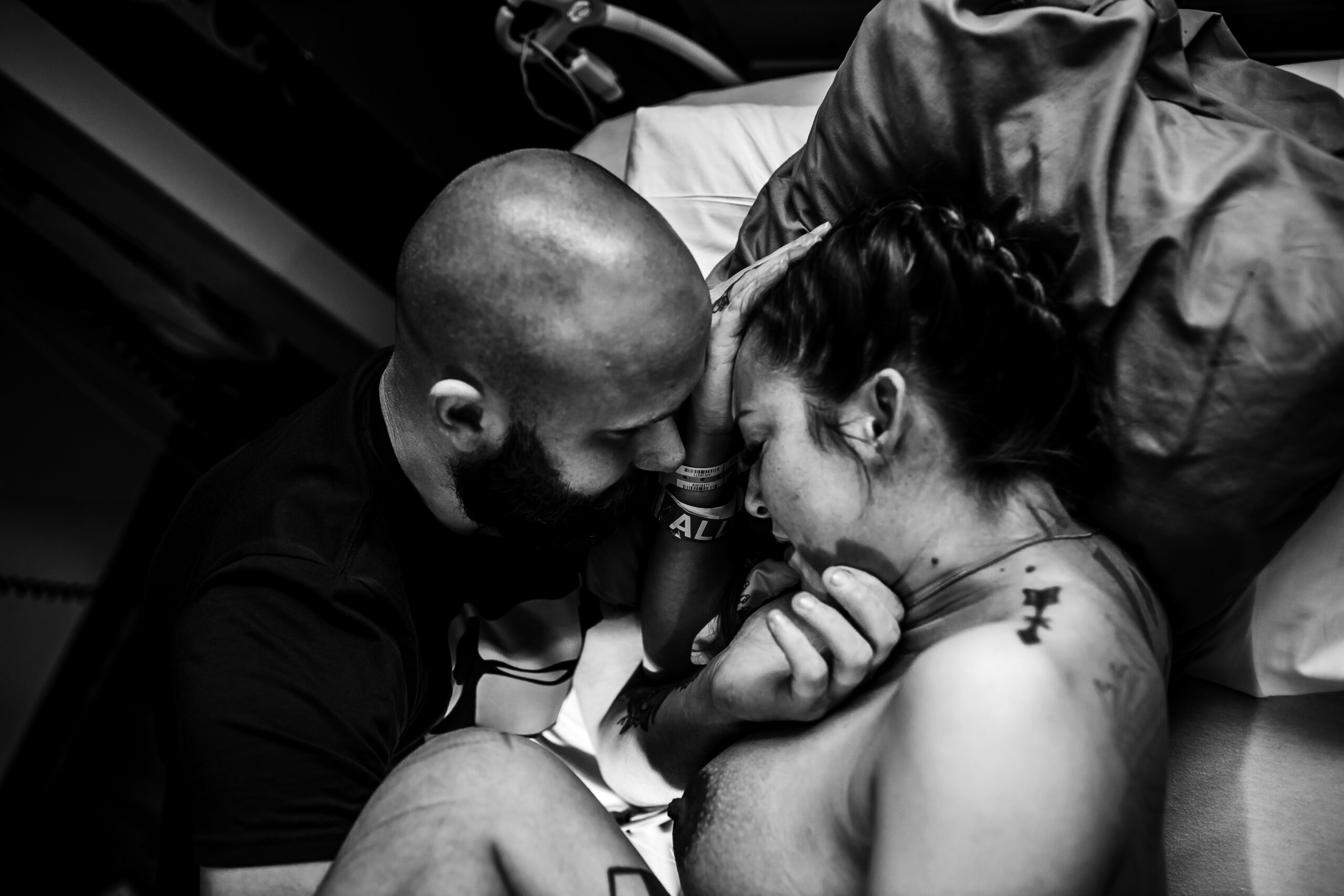Partner supporting mother during labor with a close and emotional moment, documented in a Fort Worth birth photography style.