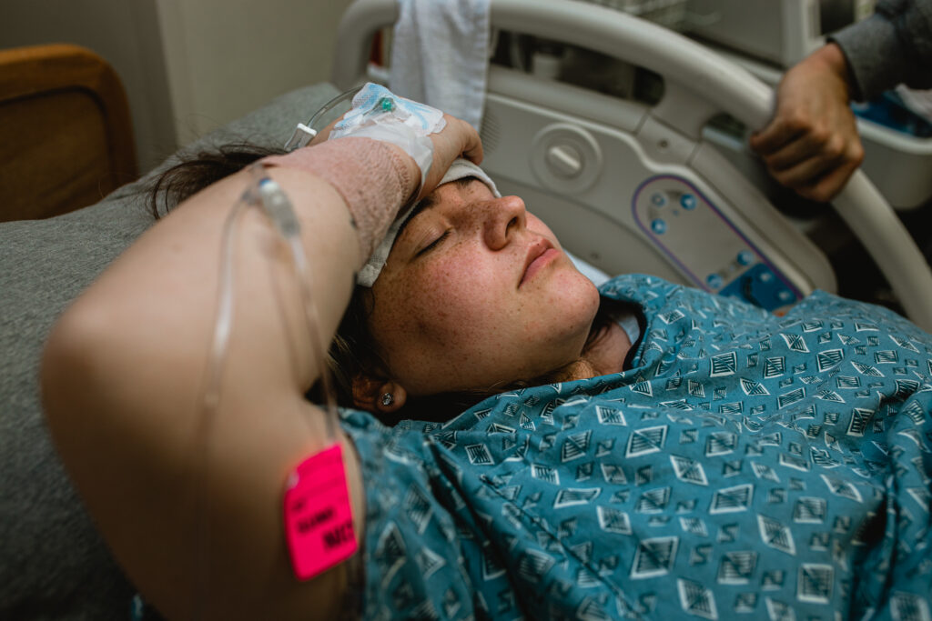 Mother resting between contractions while her partner offers support during labor.