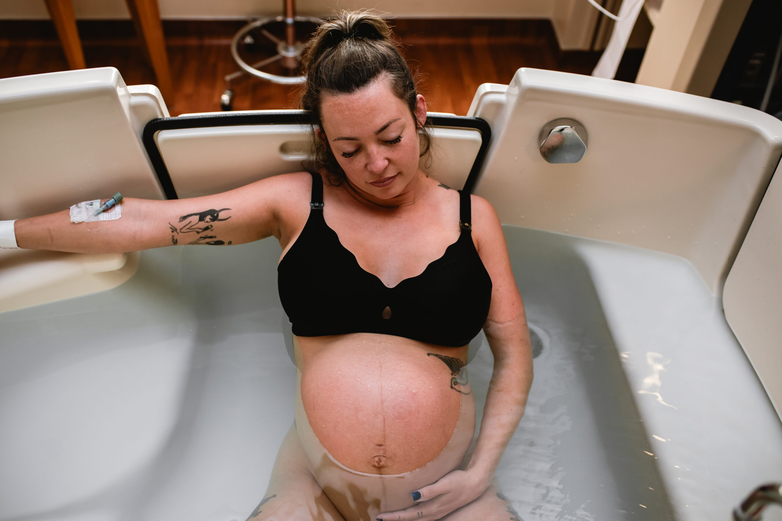 Mother laboring in a birthing tub during a peaceful water birth documented by a Fort Worth birth photographer.